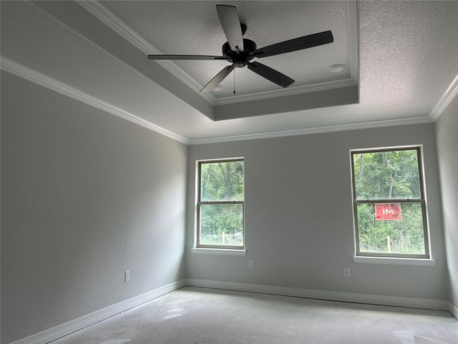 Spare room with ornamental molding, a textured ceiling, baseboards, and unfinished concrete flooring | Image 9