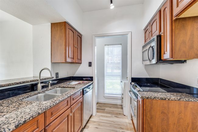 Kitchen has granite countertops, wood cabinets. | Image 8