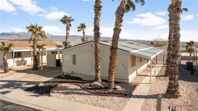 View of front of home with a carport, driveway, and a shingled roof | Image 64