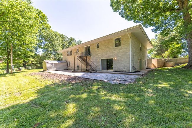 Back of house with stairway, a patio, and stone siding | Image 26