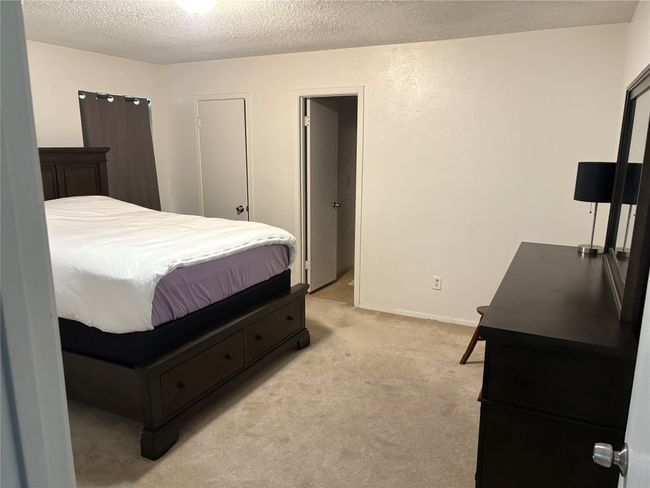 Bedroom featuring light colored carpet and a textured ceiling | Image 8