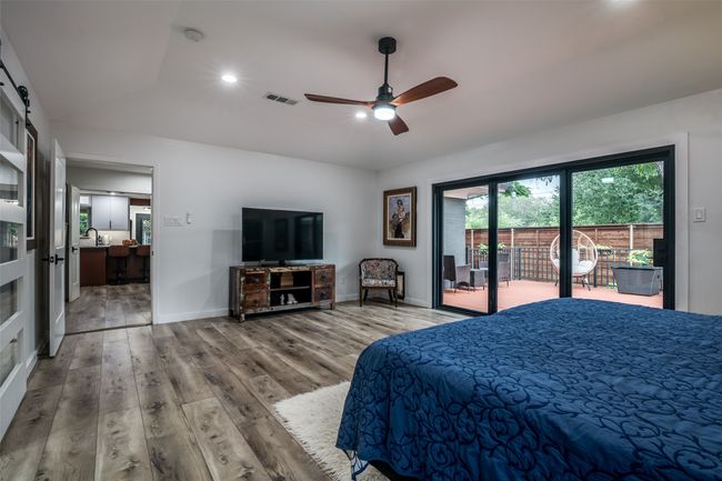 Bedroom with access to outside, lofted ceiling, wood finished floors, ceiling fan, and recessed lighting | Image 19