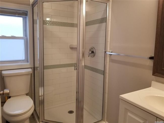 Full bathroom featuring a shower stall, toilet, and vanity | Image 13