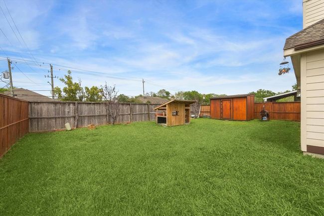Large backyard with privacy fencing, an 8'x12' storage shed, and unfinished kids playhouse. Seller will remove the playhouse if preferred. | Image 21