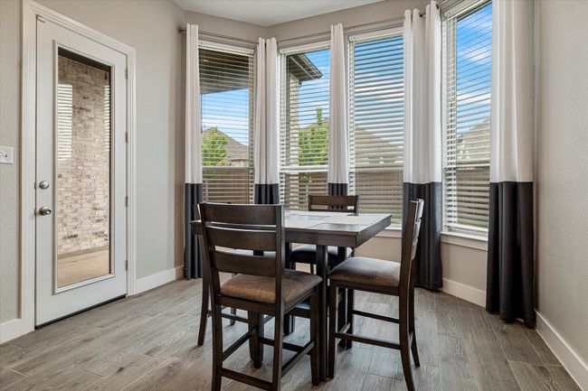 Dining room with baseboards and wood finished floors | Image 9
