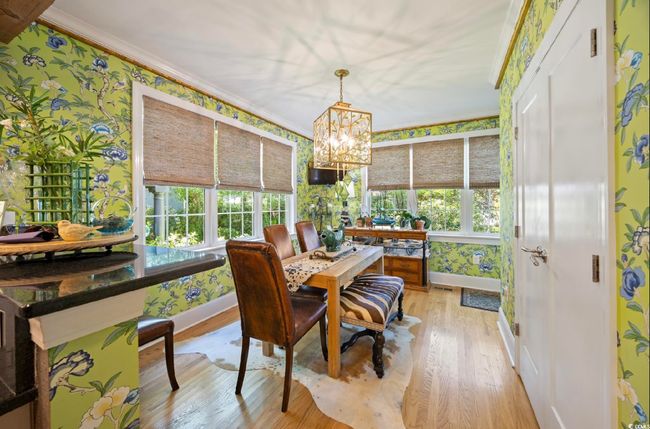 Sunroom featuring ornamental molding, hardwood / wood-style flooring, wallpapered walls, and a chandelier | Image 23