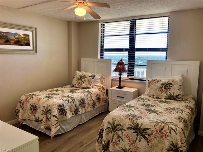 Bedroom with a textured ceiling, ceiling fan, and dark wood-style flooring | Image 16