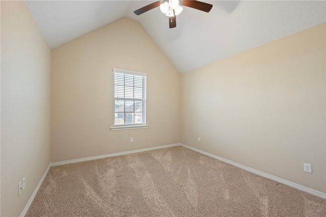Empty room with carpet floors, a ceiling fan, and lofted ceiling | Image 24