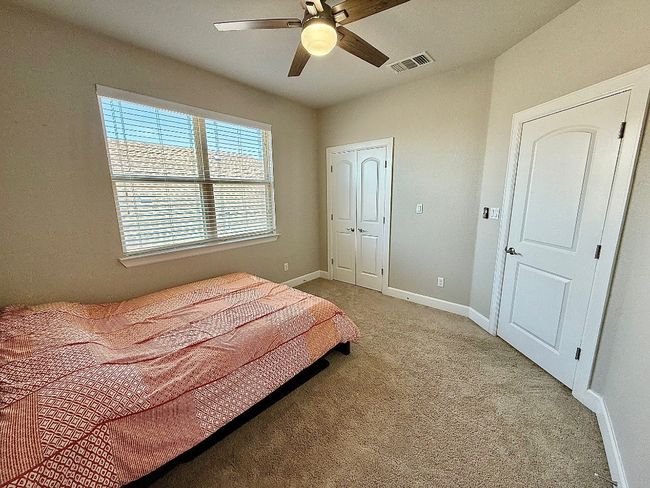 Bedroom featuring light colored carpet, baseboards, a closet, and ceiling fan | Image 30