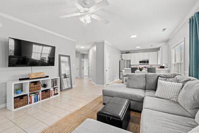 Tiled living room with ceiling fan and ornamental molding | Image 3