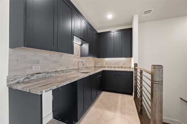 A wet bar located just off the game room creates an additional entertainment area. | Image 17