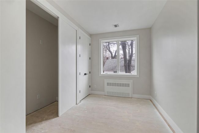 Unfurnished room with radiator heating unit, baseboards, and visible vents | Image 24