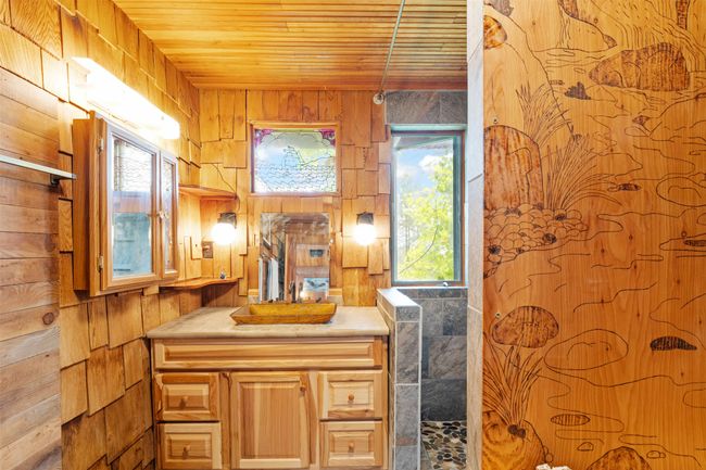Bathroom with wooden ceiling, wooden walls, and vanity | Image 24