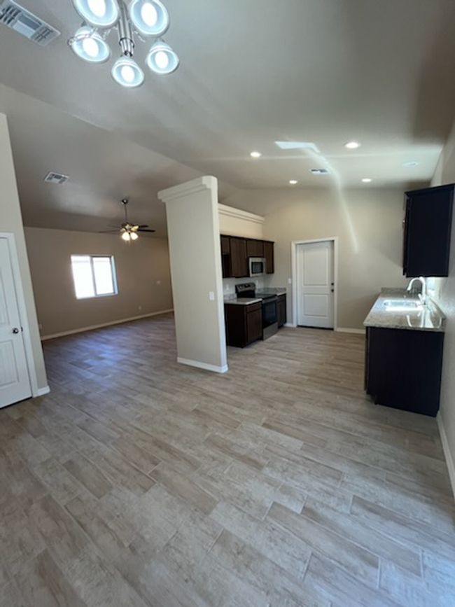 Unfurnished living room featuring baseboards, a sink, a ceiling fan, light wood finished floors, and recessed lighting | Image 5