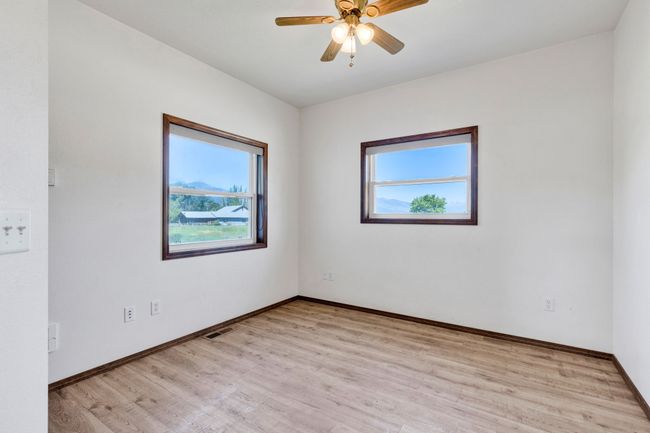 Spare room with plenty of natural light, light wood-style floors, baseboards, and ceiling fan | Image 26