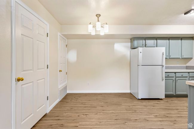 Unfurnished dining area featuring light wood-type flooring, a chandelier, and baseboards | Image 5