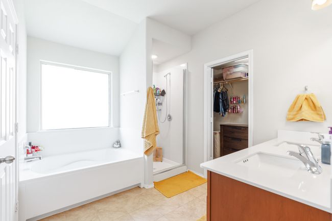 Full bath with a stall shower, a garden tub, a spacious closet, double vanity, and tile patterned floors | Image 22