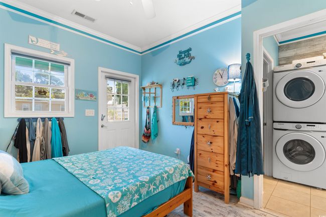 Bedroom featuring stacked washing machine and dryer, ornamental molding, and a ceiling fan | Image 17