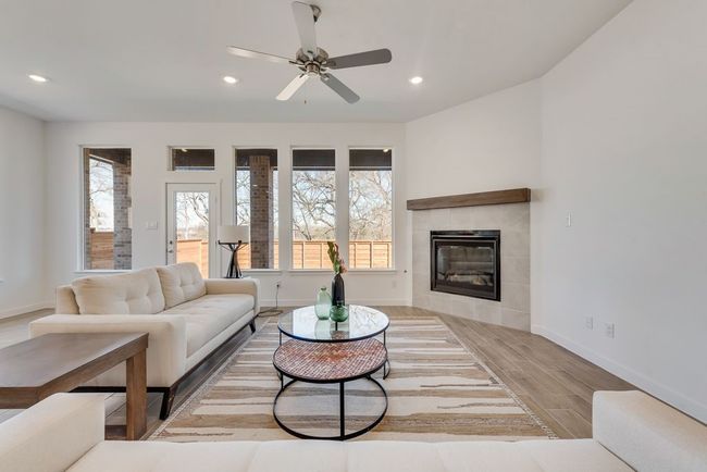 Living area featuring wood finished floors, recessed lighting, plenty of natural light, ceiling fan, and a tile fireplace | Image 13