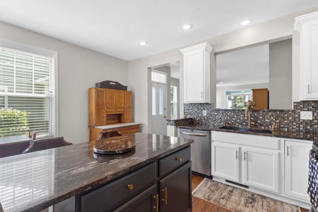 Center island with granite countertop provides a great place to bake, and prepare meals. | Image 24