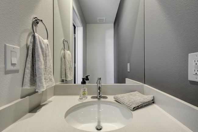 Bathroom featuring a textured wall and vanity | Image 21