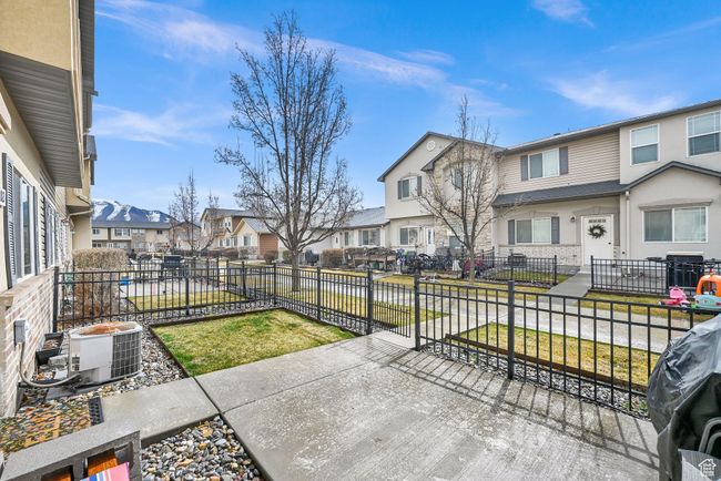 View of patio / terrace featuring a fenced front yard, a residential view, a grill, and cooling unit | Image 4