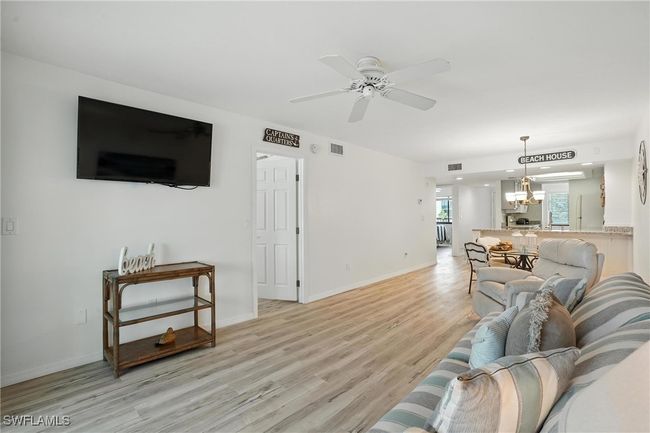 Living area featuring light wood-style flooring, ceiling fan, and recessed lighting | Image 9