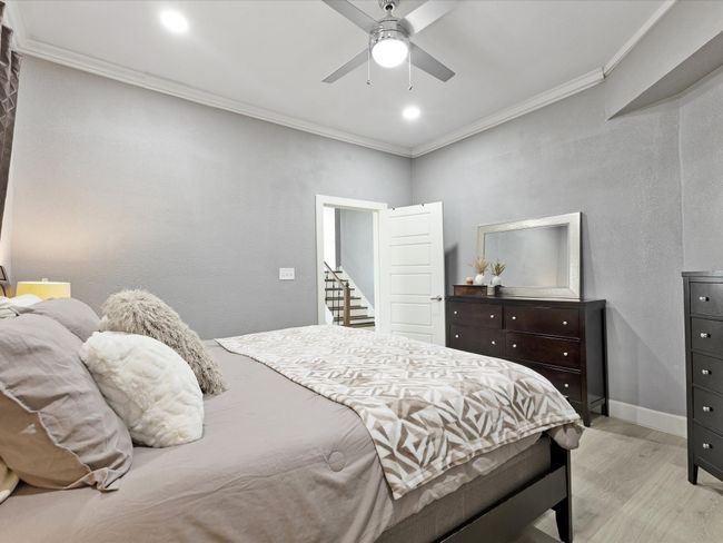 Bedroom with light wood finished floors, crown molding, baseboards, ceiling fan, and recessed lighting | Image 11