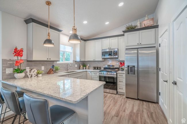 Kitchen with sink, hanging light fixtures, kitchen peninsula, and stainless steel appliances | Image 31