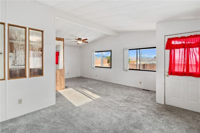 Carpeted living room featuring lofted ceiling, visible vents, and a healthy amount of sunlight | Image 7