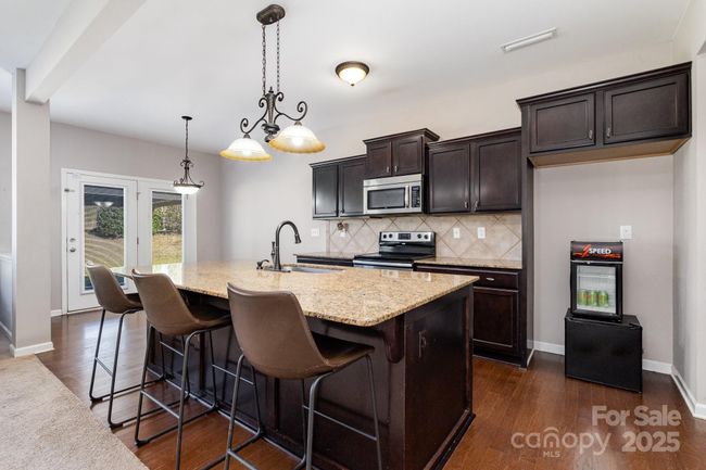 Kitchen offers ample cabinetry, large island for eating and gathering. | Image 8