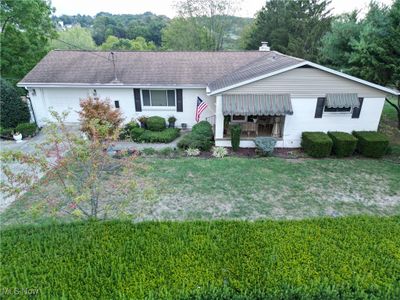 Ranch-style home with a garage and a front lawn | Image 1