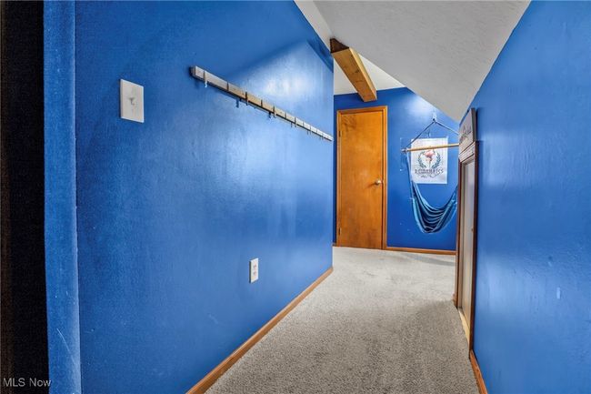 Hallway featuring baseboards, lofted ceiling, and carpet | Image 25