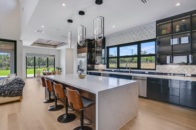 Kitchen featuring dishwasher, a kitchen island, modern cabinets, light wood flooring | Image 15