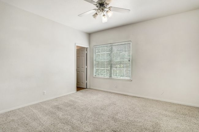 Carpeted spare room featuring a ceiling fan | Image 13