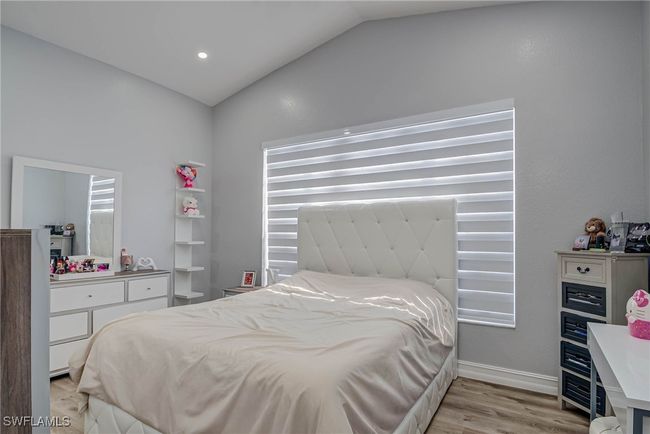 Bedroom with vaulted ceiling, light wood-type flooring, and baseboards | Image 9
