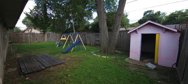 Fenced backyard with a playground and a shed | Image 32