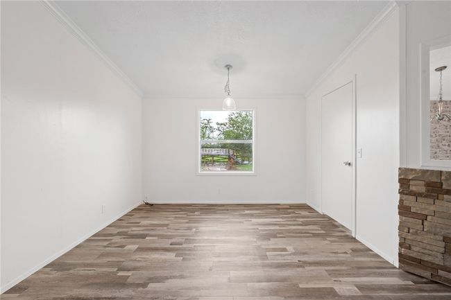 Unfurnished dining area featuring wood finished floors and crown molding | Image 10
