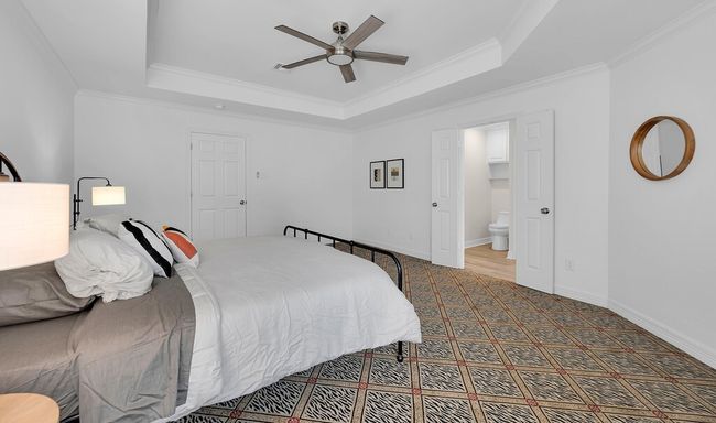 Primary bedroom view from seating area, high end designer carpeting, new modern ceiling fan, and a raised ceiling | Image 21