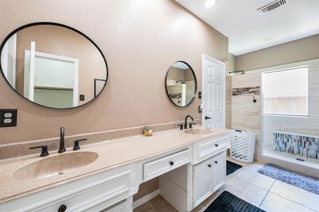 Primary bathroom with a dual sink vanity and walk-in shower. | Image 13