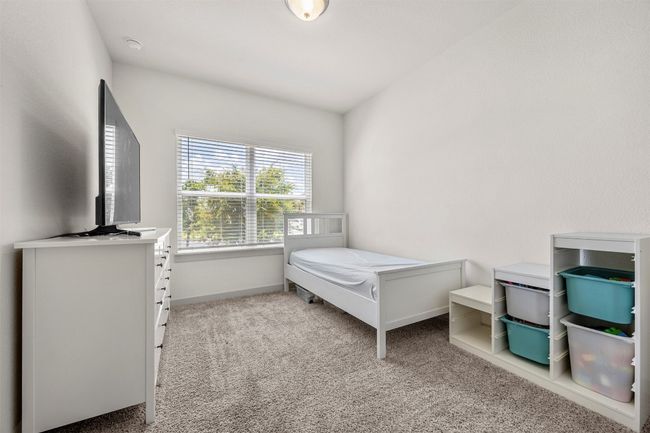 Another spacious secondary bedroom with soft carpeting, large windows for natural light, and a neutral color scheme, making it a versatile space for any need. | Image 22