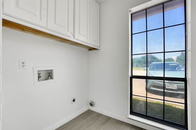 Washroom featuring cabinet space, hookup for an electric dryer, and plenty of natural light | Image 15
