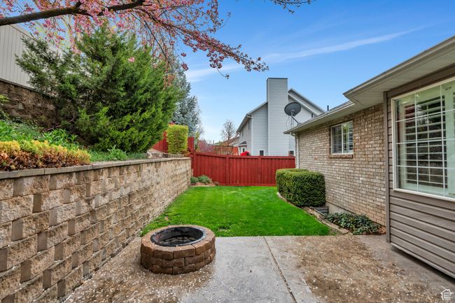 View of yard featuring a fire pit, a fenced backyard, and a patio | Image 32
