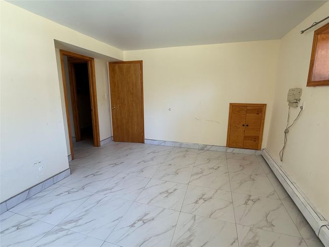 Spare room featuring a baseboard heating unit, baseboards, and marble finish floor | Image 14