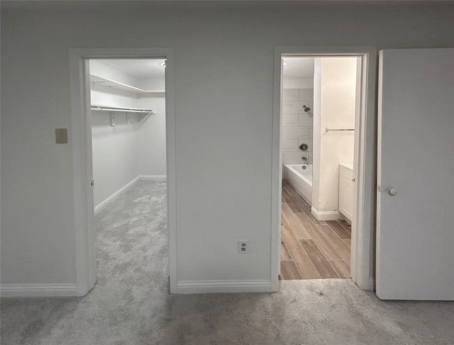 Primary bedroom with a closet, light colored carpet, ensuite bathroom, and a spacious closet | Image 18