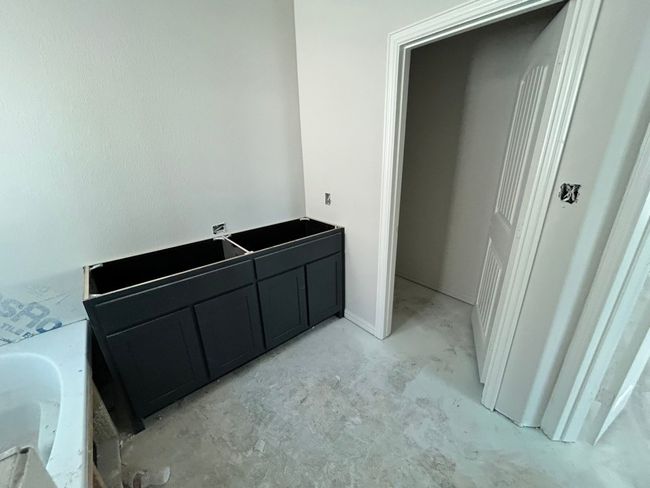 Full bathroom with a tub to relax in and unfinished concrete floors | Image 10