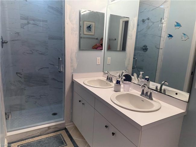 Full bathroom featuring a stall shower and double vanity | Image 13