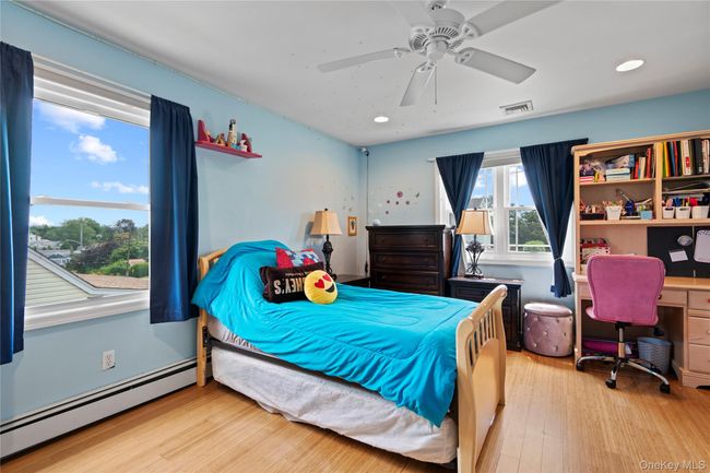 Bedroom with a baseboard radiator, light wood-style floors, a desk, ceiling fan, and recessed lighting | Image 12
