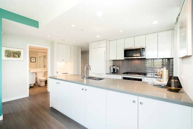 Kitchen with stainless steel appliances, a sink, dark wood-style floors, backsplash, and recessed lighting | Image 4