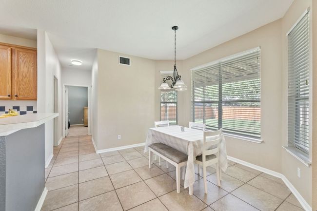 Dining space featuring light tile patterned floors and a chandelier | Image 9